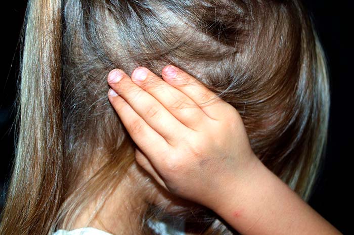 Imagen de una niña tapándose los oídos