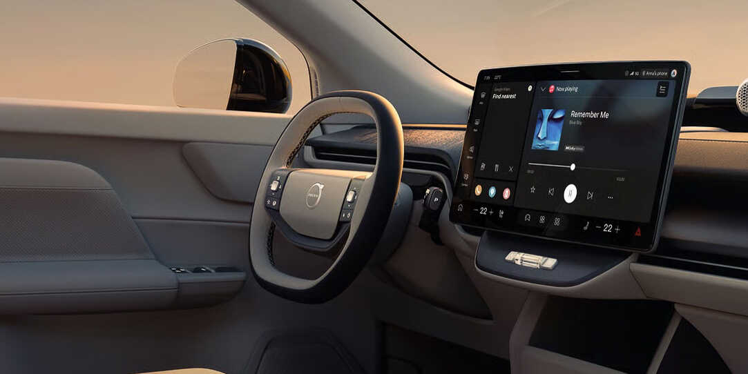 Salpicadero minimalista del Volvo EX60 que muestra una gran pantalla táctil vertical central con el sistema de infoentretenimiento y volante ergonómico.